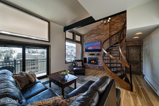 508 E Lionshead Cir Unit 502, Vail, CO 81657 - living room with a brick fireplace, a chandelier, baseboard heating, stairway, and wood finished floors