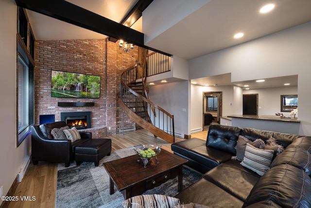 508 E Lionshead Cir Unit 502, Vail, CO 81657 - living room with high vaulted ceiling, stairway, a brick fireplace, wood finished floors, and brick wall