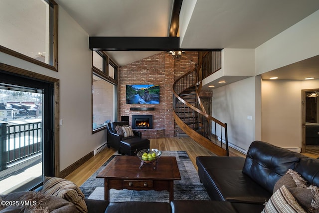 508 E Lionshead Cir Unit 502, Vail, CO 81657 - living room with wood finished floors, plenty of natural light, a fireplace, stairs, and high vaulted ceiling