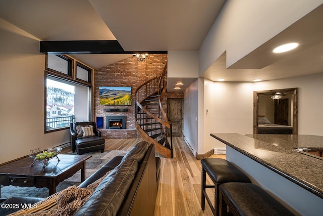 508 E Lionshead Cir Unit 502, Vail, CO 81657 - living room featuring stairway, a fireplace, light wood-style floors, ceiling fan, and a chandelier