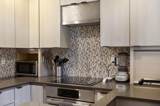 1552 Matterhorn Cir Unit 9, Vail, CO 81657 - kitchen featuring appliances with stainless steel finishes, tasteful backsplash, exhaust hood, and dark countertops