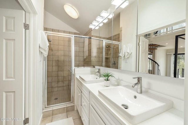 bathroom with a stall shower, tile patterned flooring, vaulted ceiling, and a sink