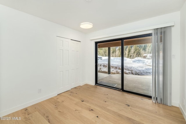 unfurnished room featuring baseboards and light wood finished floors