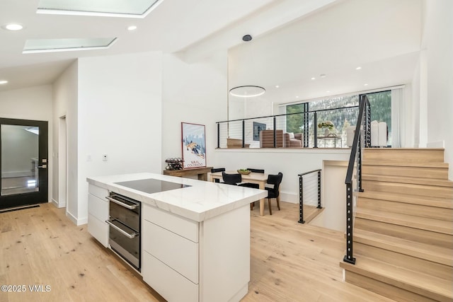 kitchen featuring black electric stovetop, recessed lighting, light wood-style floors, white cabinetry, and modern cabinets