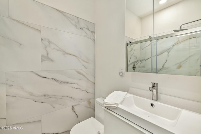 full bath with toilet, vanity, and a marble finish shower