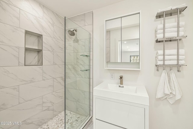 full bath featuring a tile shower and vanity