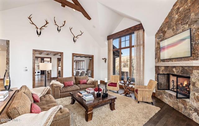 living room with hardwood / wood-style floors, beam ceiling, a fireplace, and high vaulted ceiling