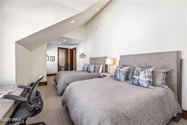 carpeted bedroom with high vaulted ceiling