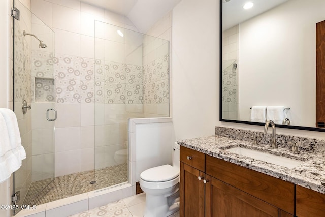 bathroom featuring vanity, tile patterned floors, a shower with door, and toilet