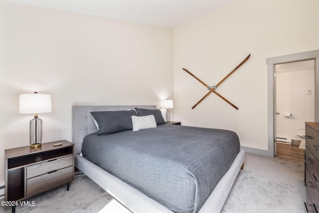 carpeted bedroom featuring connected bathroom and a baseboard radiator