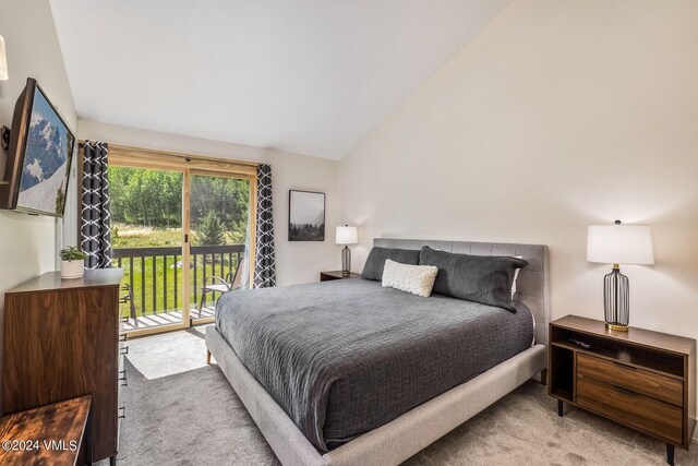 bedroom with lofted ceiling, carpet flooring, and access to exterior