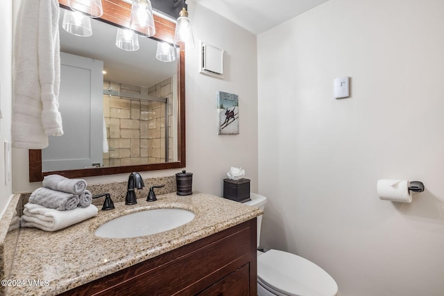 bathroom featuring walk in shower, vanity, and toilet