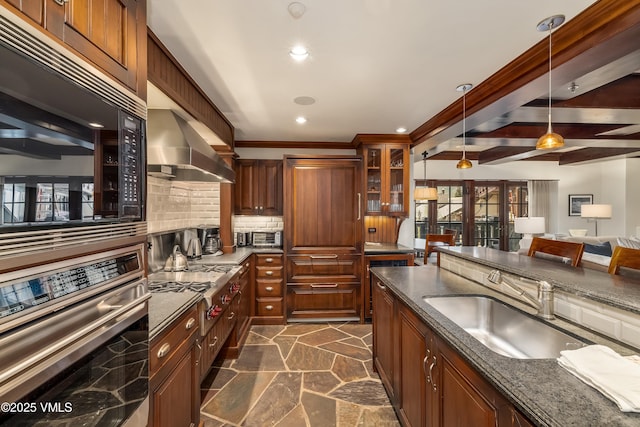 1 Willow Bridge Rd Unit 36, Vail, CO 81657 - kitchen with appliances with stainless steel finishes, a sink, tasteful backsplash, dark stone finish floors, and hanging light fixtures