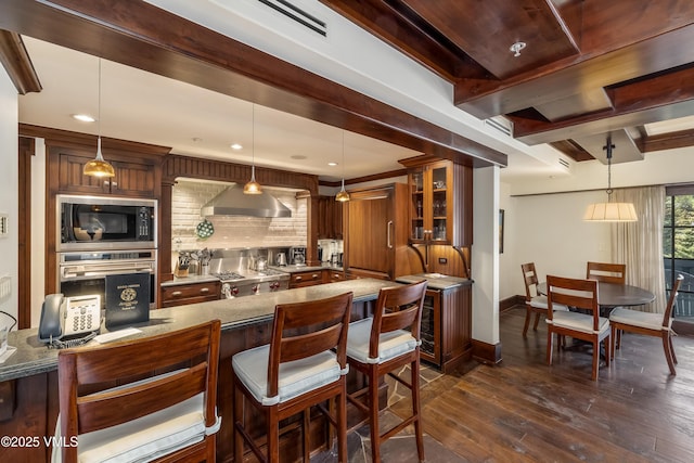 1 Willow Bridge Rd Unit 36, Vail, CO 81657 - bar area featuring wall chimney exhaust hood, built in microwave, dark wood-type flooring, baseboards, and tasteful backsplash