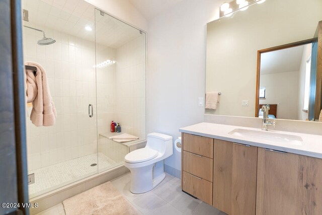 bathroom featuring vanity, toilet, an enclosed shower, and tile patterned flooring