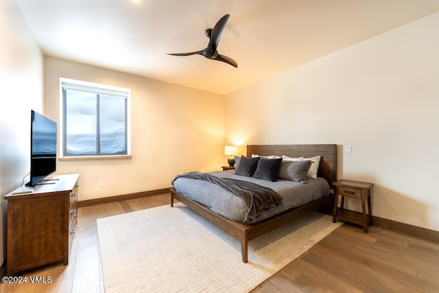 bedroom with light hardwood / wood-style floors and ceiling fan