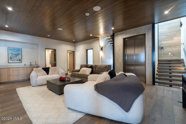 living room with wood ceiling, elevator, and light wood-type flooring