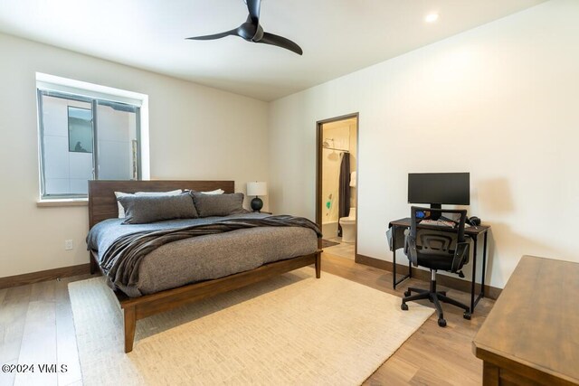 bedroom featuring ensuite bathroom, ceiling fan, and light wood-type flooring