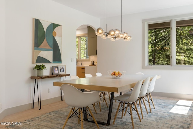 220 Singletree Rd, Edwards, CO 81632 - dining room with a chandelier, light wood-style floors, arched walkways, and baseboards