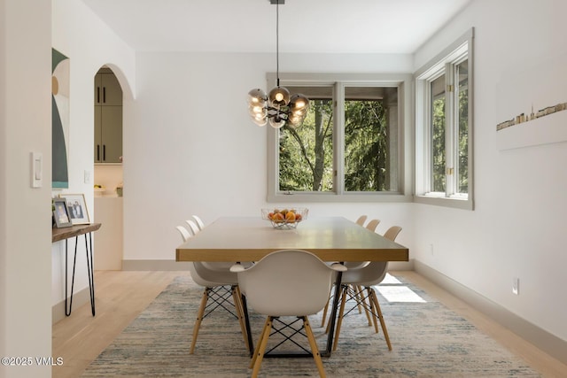220 Singletree Rd, Edwards, CO 81632 - dining space with a chandelier, light wood finished floors, arched walkways, and baseboards