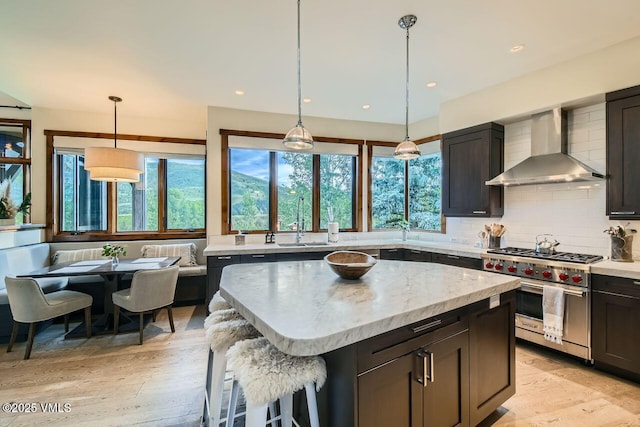 44 Conestoga Cir, Edwards, CO 81632 - kitchen with wall chimney range hood, designer range, light wood-type flooring, decorative backsplash, and recessed lighting
