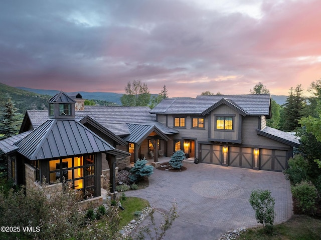 44 Conestoga Cir, Edwards, CO 81632 - view of front facade featuring a standing seam roof, driveway, a metal roof, stone siding, and an attached garage