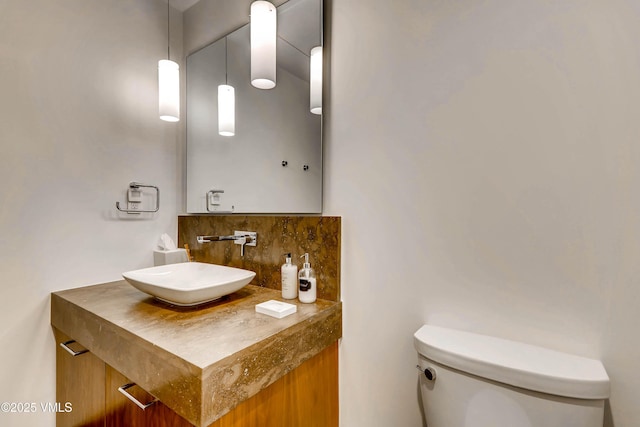 bathroom with vanity, toilet, and tasteful backsplash