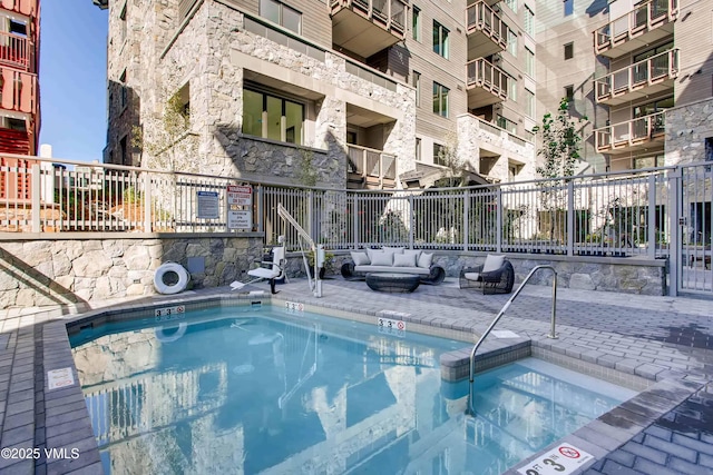 view of pool with an outdoor living space, a patio, and fence