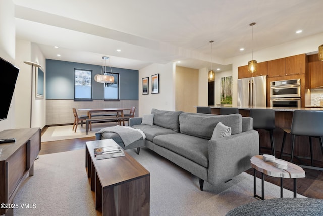 living room featuring recessed lighting, a wainscoted wall, and dark wood-type flooring