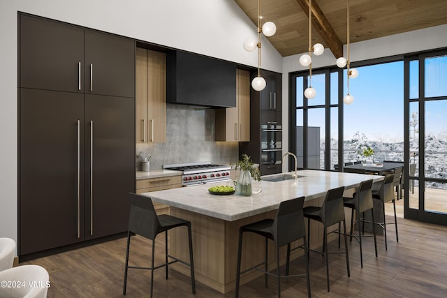 kitchen featuring pendant lighting, double oven range, a kitchen breakfast bar, and an island with sink