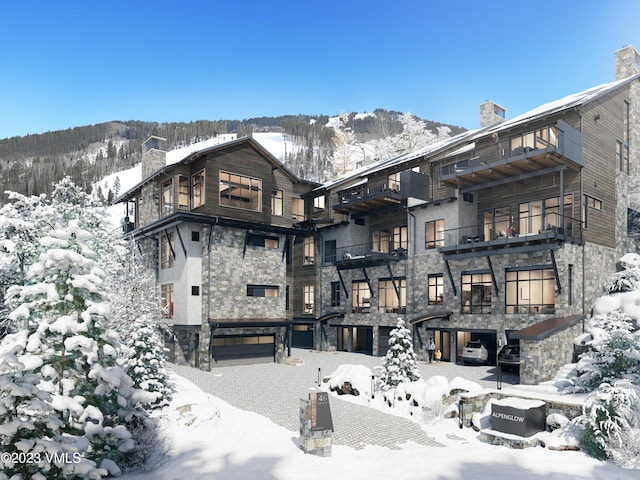 snow covered house featuring a mountain view