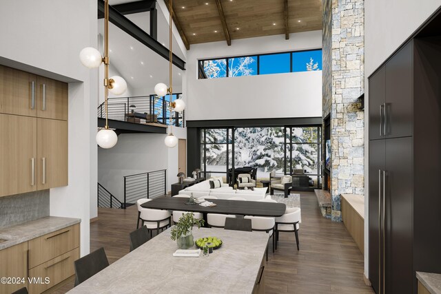 dining room featuring dark hardwood / wood-style flooring, a towering ceiling, and wood ceiling