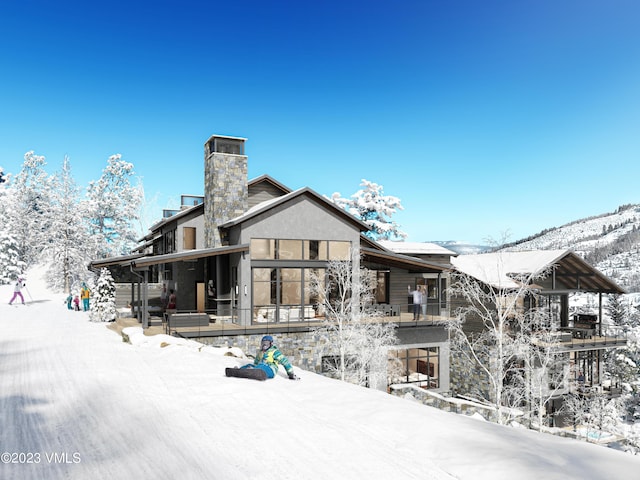 snow covered rear of property with a porch