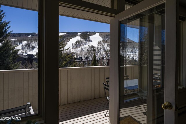 snow covered back of property featuring a mountain view