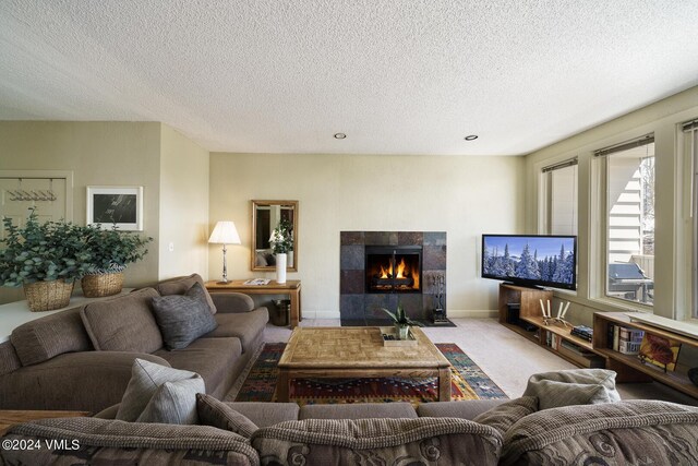 carpeted living room with a fireplace and a textured ceiling