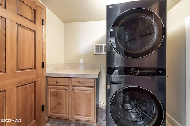 107 Lions Ln, Minturn, CO 81645 - laundry area with stacked washer and dryer, visible vents, and cabinet space