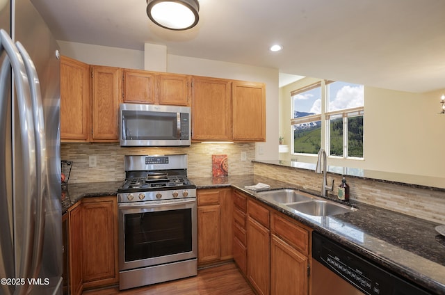 600 Nottingham Rd Unit 8, Avon, CO 81620 - kitchen with appliances with stainless steel finishes, a sink, decorative backsplash, dark stone counters, and wood finished floors
