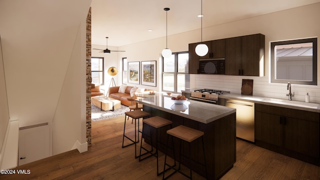 kitchen featuring sink, a breakfast bar, appliances with stainless steel finishes, dark brown cabinets, and a center island