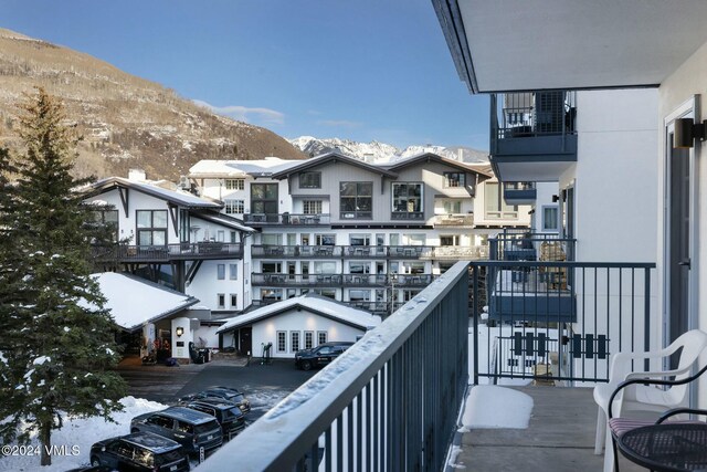 snow covered back of property with a mountain view