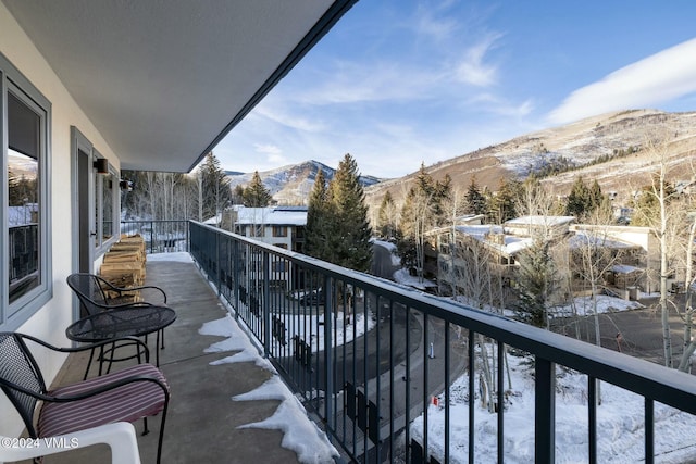 snow covered back of property with a mountain view