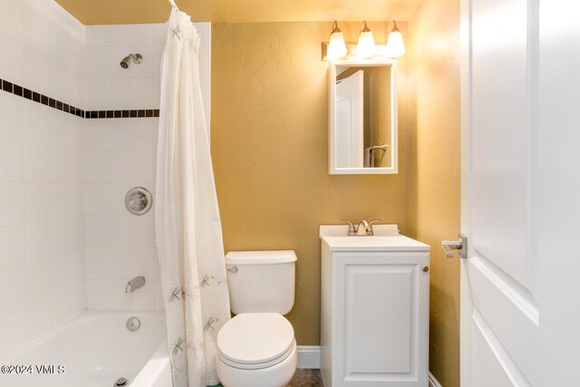 full bathroom with vanity, shower / tub combo, and toilet