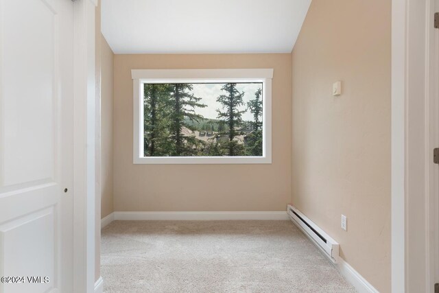 carpeted spare room featuring a baseboard radiator