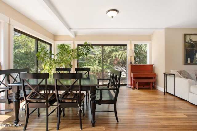 dining space with hardwood / wood-style floors and beamed ceiling