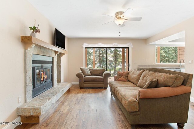 living room featuring wood-type flooring, sink, and ceiling fan