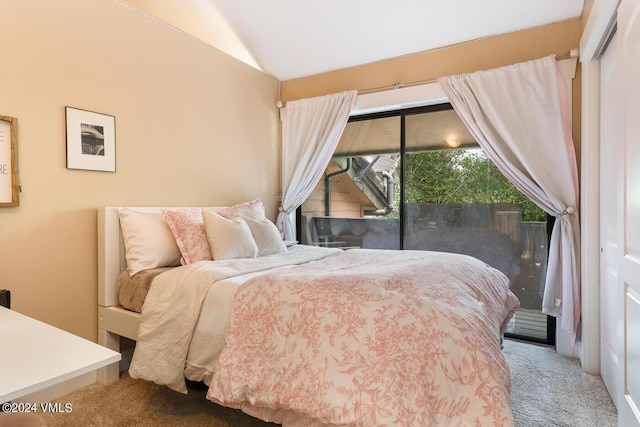 bedroom featuring access to exterior, vaulted ceiling, and carpet flooring