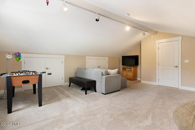 interior space featuring light carpet, vaulted ceiling, and track lighting