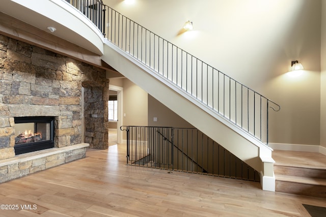 88 E Double Hitch, Eagle, CO 81631 - unfurnished living room featuring a towering ceiling, wood finished floors, baseboards, and a stone fireplace