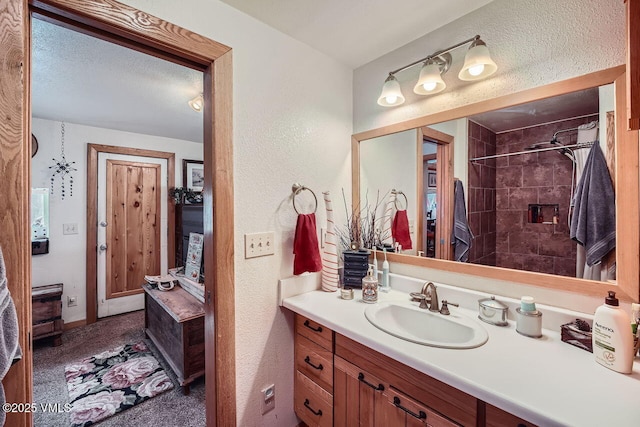 425 Howard St, Eagle, CO 81631 - full bath with vanity, a tile shower, and a textured wall