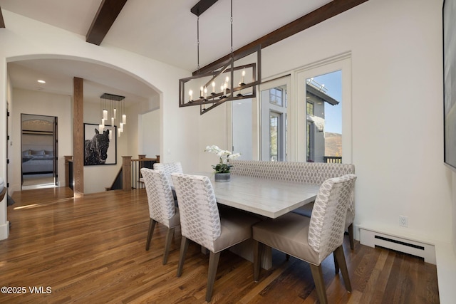 446 Kensington Dr, Edwards, CO 81632 - dining room featuring a baseboard heating unit, a chandelier, wood finished floors, beam ceiling, and arched walkways