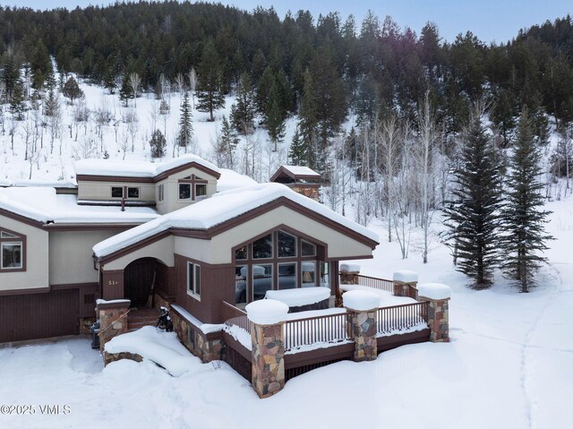 view of snow covered back of property